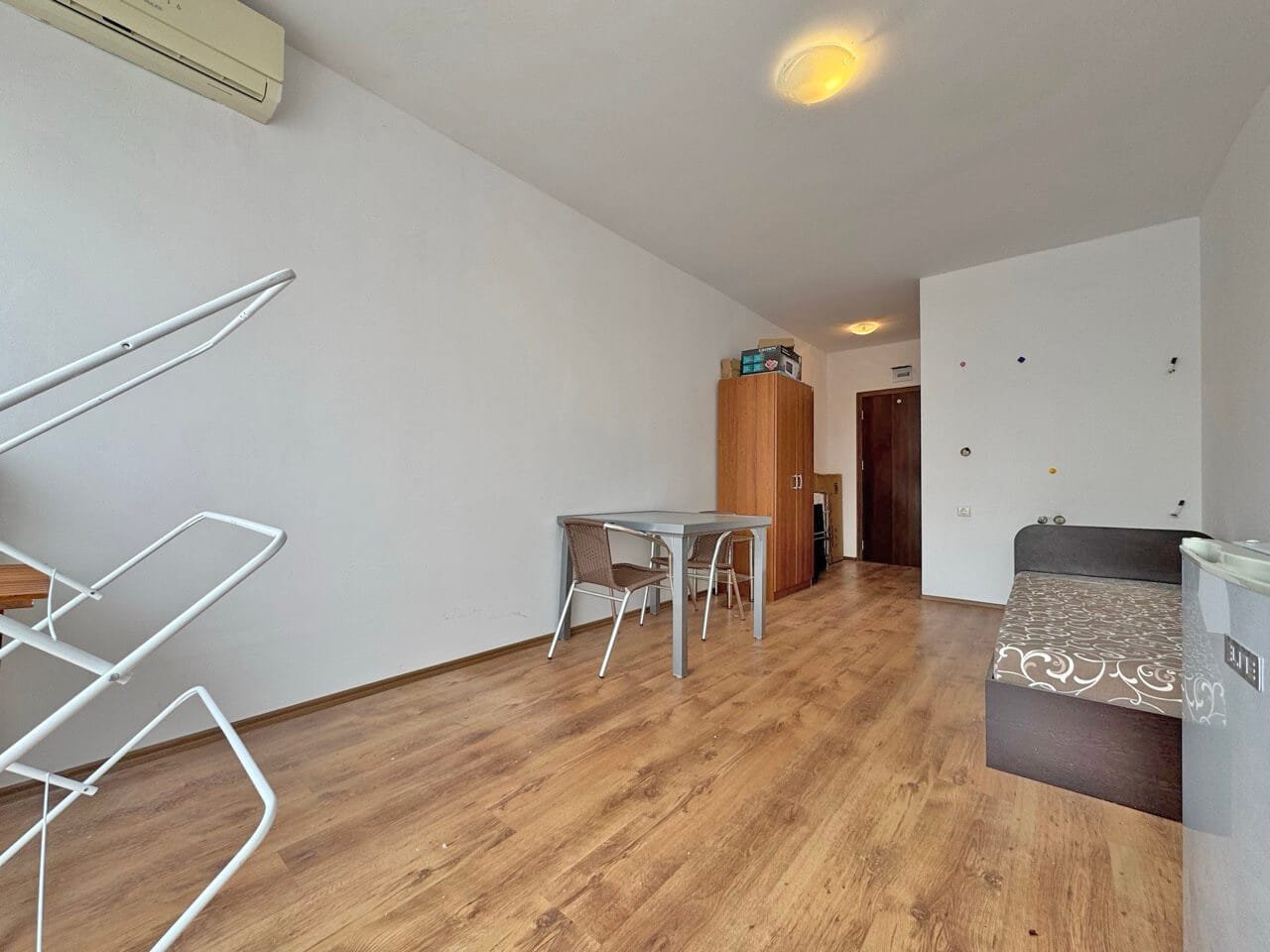 Современная квартира в Святом Власе с большой гостиной и обеденной зоной, светлые стены, деревянный пол, аккуратная мебель.