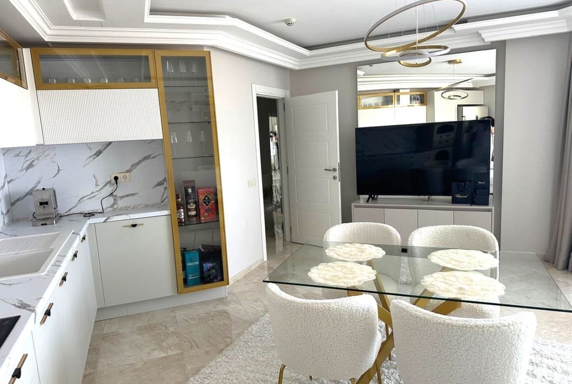 Современный интерьер квартиры в Болгарии с обставленным кухонным уголком и стильной обеденной зоной.