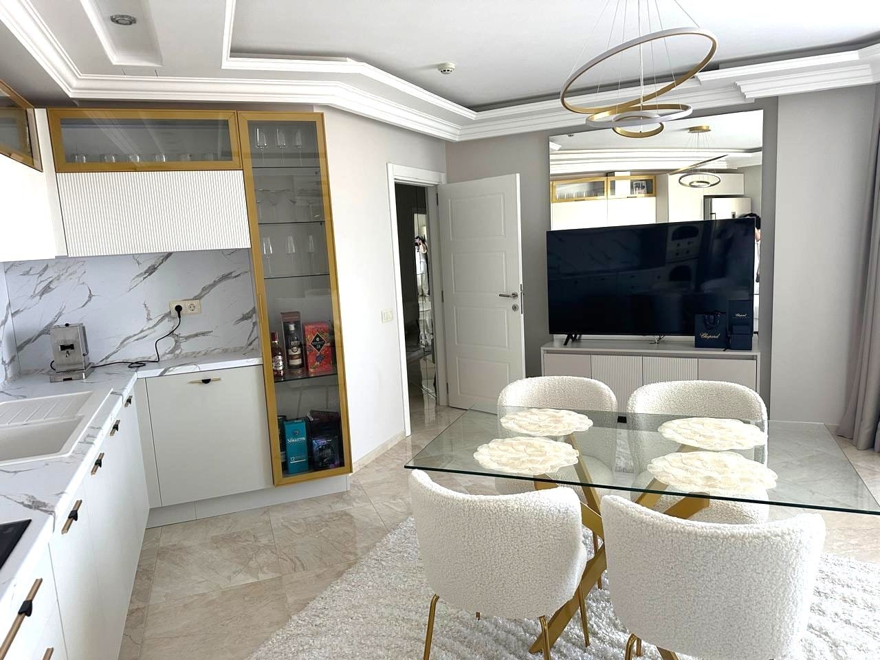 Современный интерьер квартиры в Болгарии с обставленным кухонным уголком и стильной обеденной зоной.