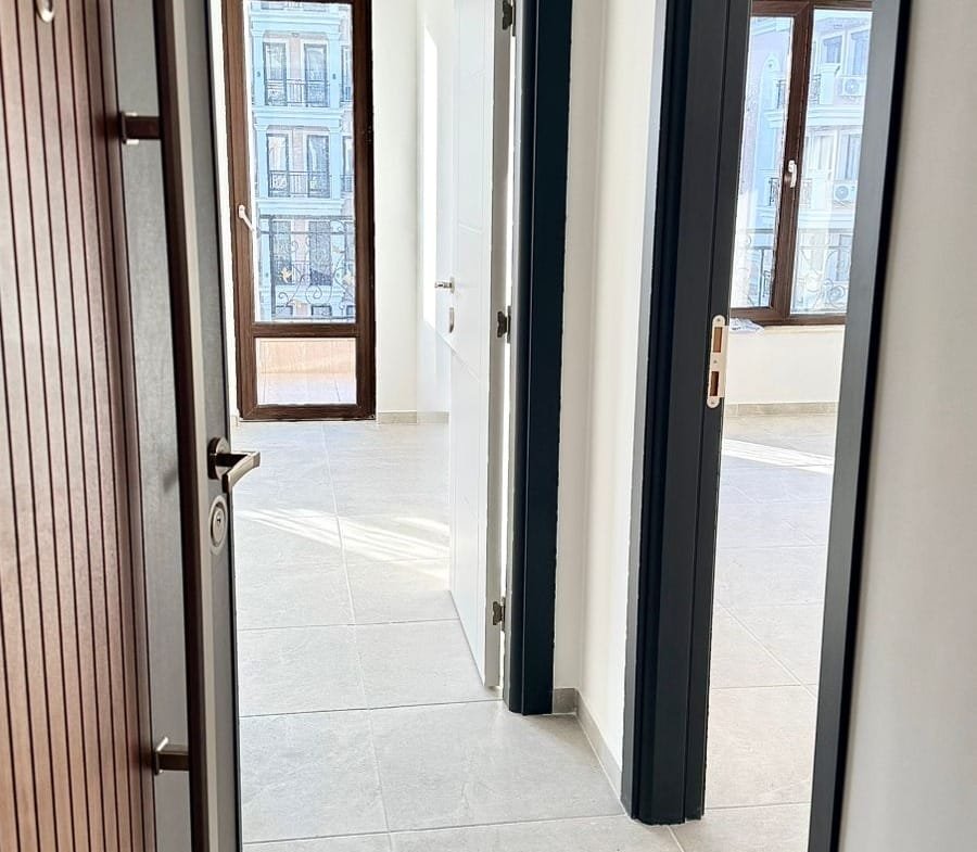 Современный интерьер квартиры в Болгарии с ярким освещением, открытыми дверями и плиточным полом. Отличная возможность для покупки.