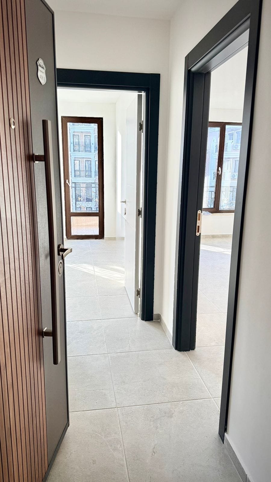 Современный интерьер квартиры в Болгарии с ярким освещением, открытыми дверями и плиточным полом. Отличная возможность для покупки.