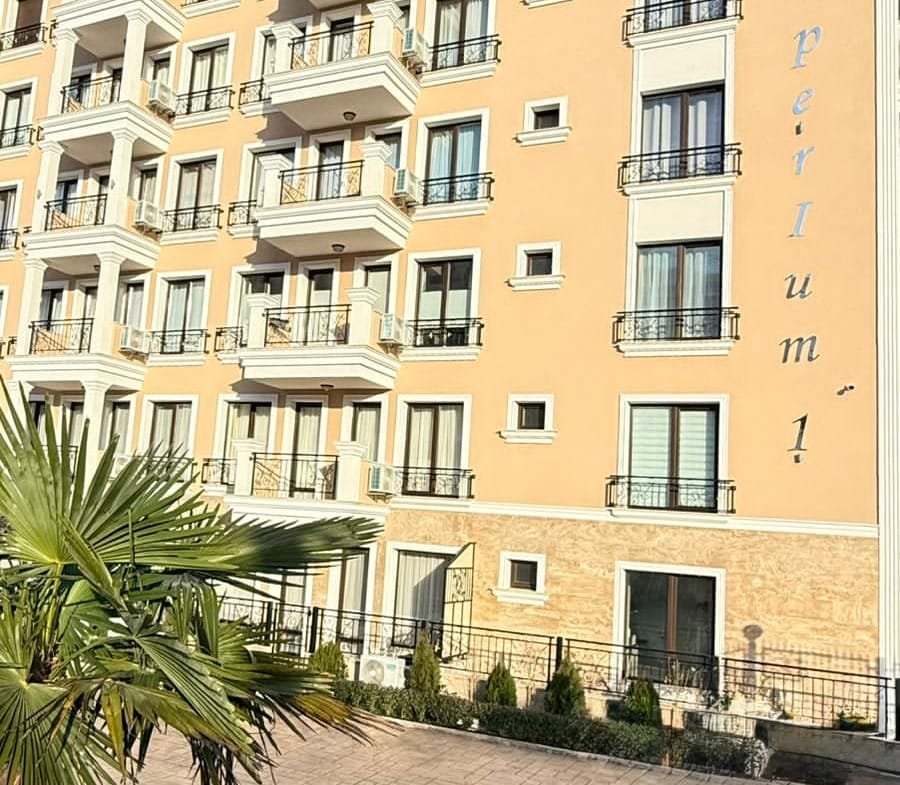 Современный жилой комплекс Emperium в Болгарии, с балконами и зелеными насаждениями вокруг, подходящий для продажи и покупки недвижимости.