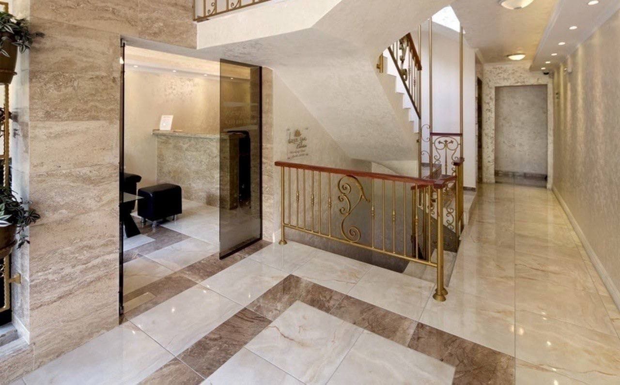 Современный холл с мраморным полом, лестницей и стильными элементами дизайна, идеальный для продажи недвижимости в Болгарии.