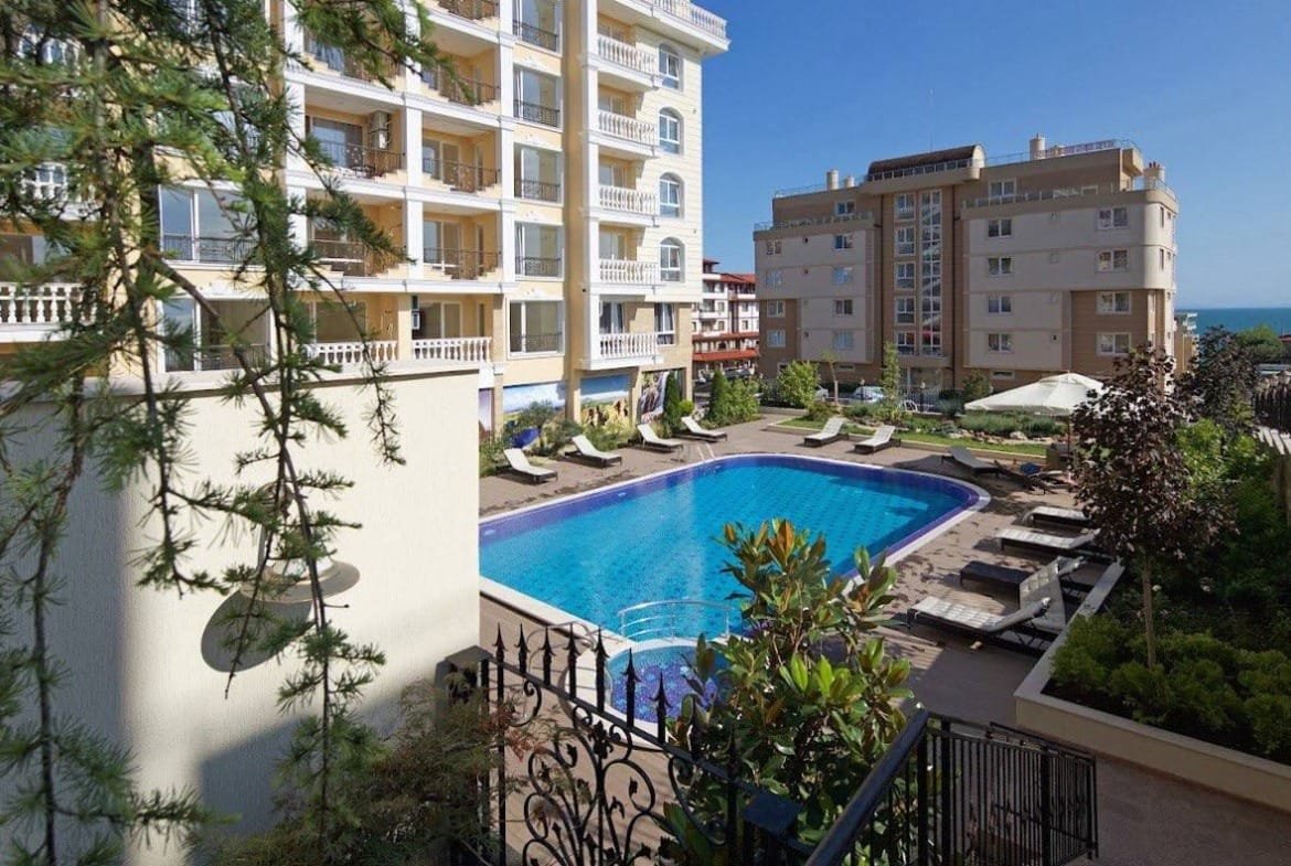 Современный жилой комплекс с бассейном и зелеными насаждениями в Болгарии, рядом с морем, подходит для покупки недвижимости.