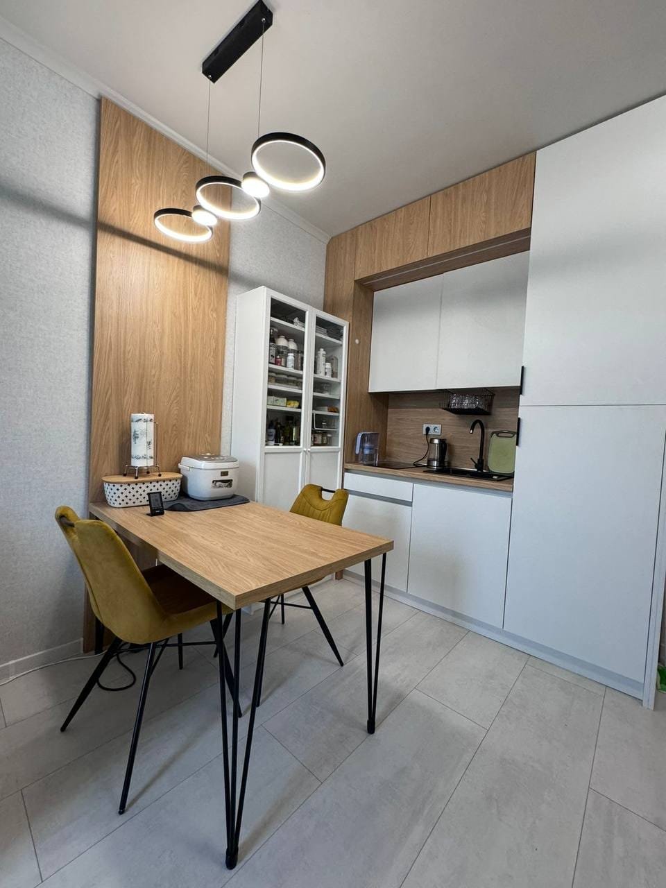 Современная кухня с деревянными элементами, столом и стульями, подходит для покупки недвижимости в Болгарии.