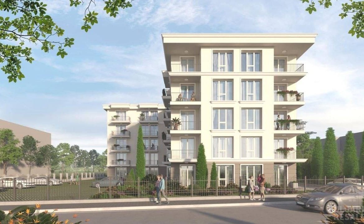 Современный жилой комплекс в Болгарии с зелеными насаждениями, балконами и парковыми местами, идеальный для покупки недвижимости.