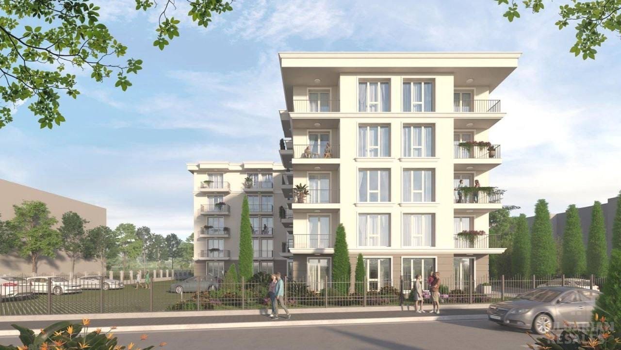 Современное многоквартирное здание с зелеными насаждениями Современный жилой комплекс в Болгарии с зелеными насаждениями, балконами и парковыми местами, идеальный для покупки недвижимости.