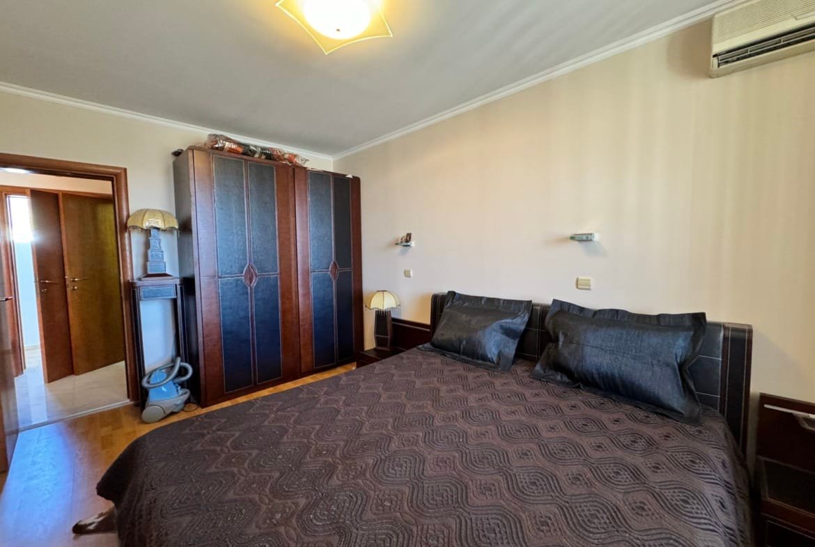 Уютная спальня с двуспальной кроватью, темными тонами, шкафом и светлом, идеально подходящая для отдыха в Болгарии.