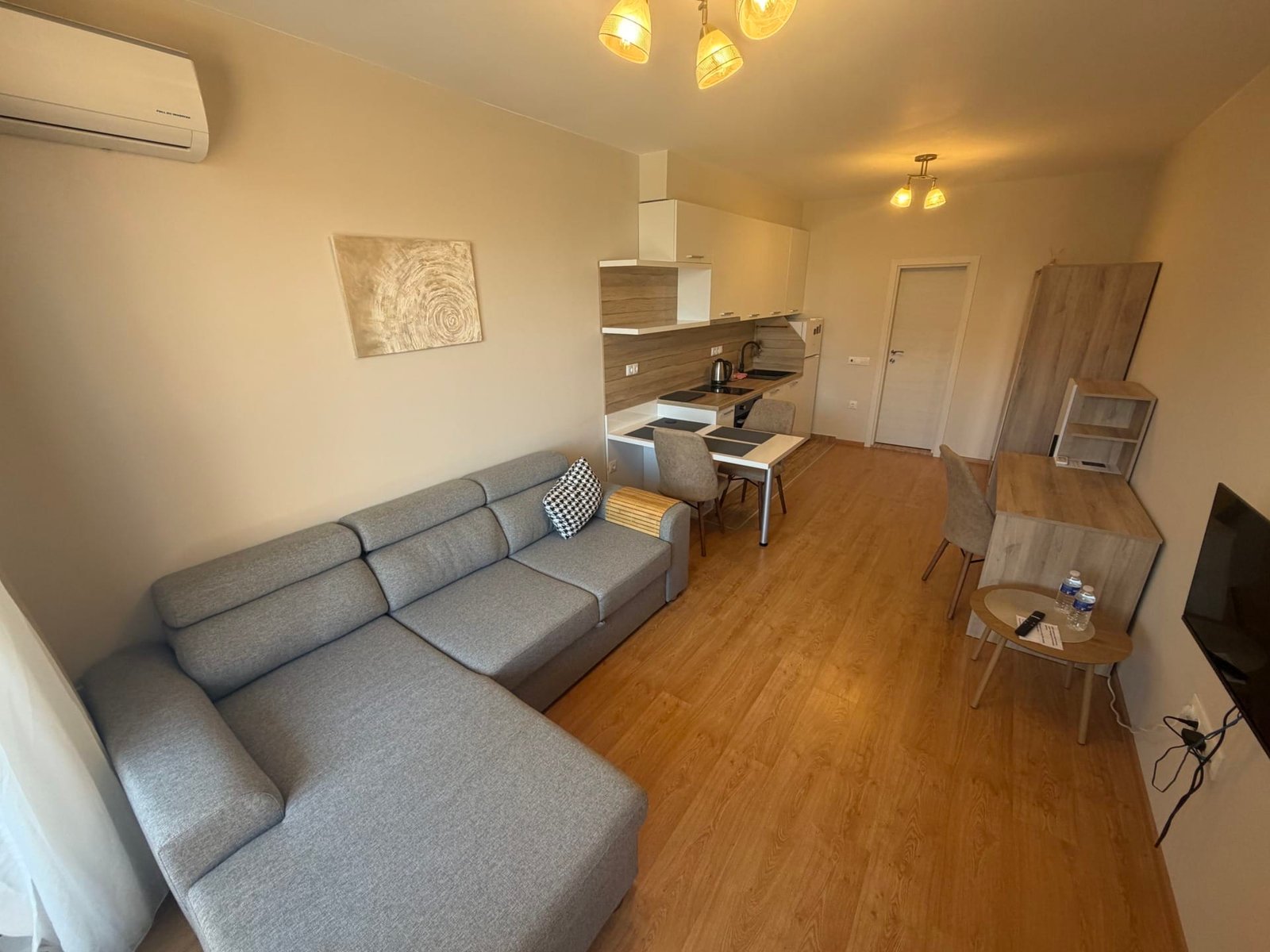 Современный интерьер квартиры в Болгарии с уютной зоной отдыха, кухонным гарнитуром и обеденной зоной.