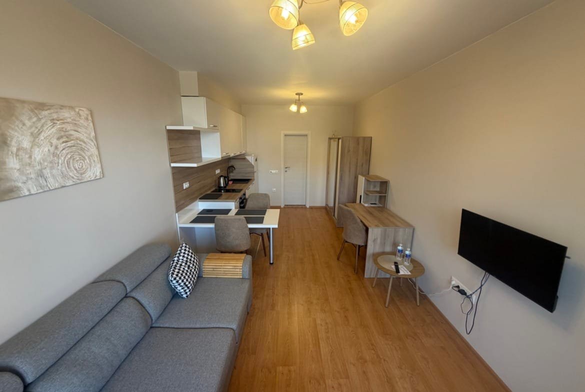 Современная квартира в Болгарии с уютной гостиной, кухней, светлым интерьером и мягкой мебелью. Идеально для покупки или аренды.