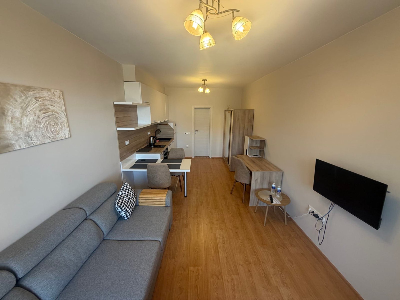 Современная квартира в Болгарии с уютной гостиной, кухней, светлым интерьером и мягкой мебелью. Идеально для покупки или аренды.