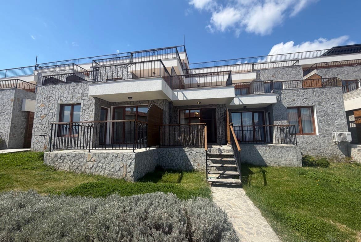 Современный таунхаус с террасой и зелеными насаждениями в Болгарии, идеальный для покупки недвижимости на побережье.