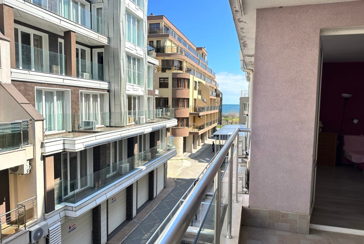 Балкон с видом на современные здания, улицу и голубое небо, отражающие атмосферу жизни в Болгарии.