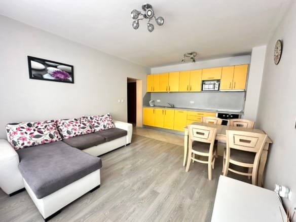 Современная квартира с уютной гостиной, кухней желтого цвета и обеденным столом, идеально подходит для жизни в Болгарии.