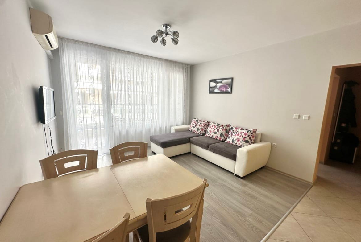 Современная квартира в Болгарии с светлым интерьером, уютной мебелью и большой гостиной, идеально подходящей для жизни и отдыха.