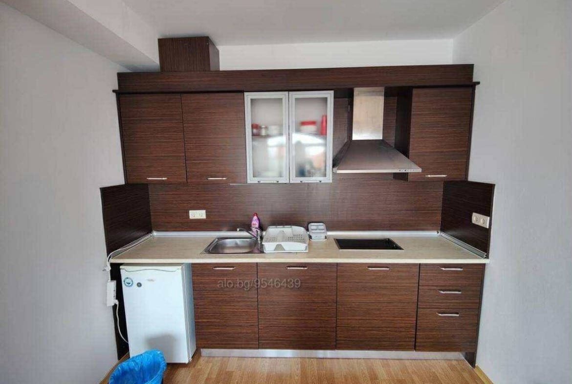 Современная кухня с мебелью из темного дерева, плитой и мойкой, готовая для продажи в Болгарии.