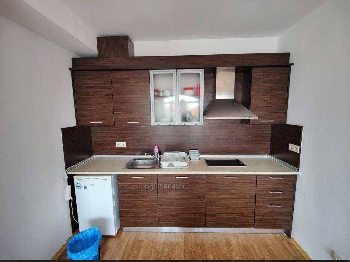 Современная кухня с мебелью из темного дерева, плитой и мойкой, готовая для продажи в Болгарии.