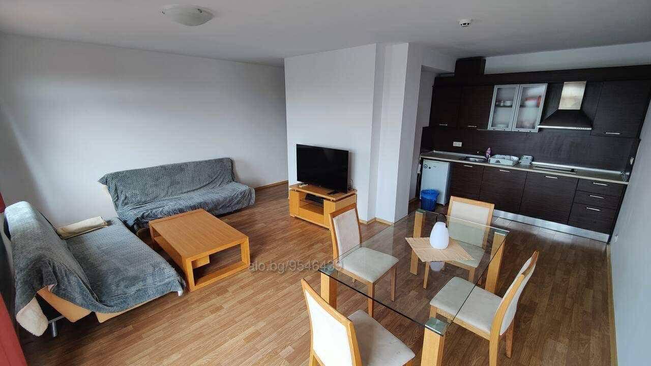 Современная квартира с кухней, гостиной и обеденной зоной, предлагающая комфорт для покупки недвижимости в Болгарии.