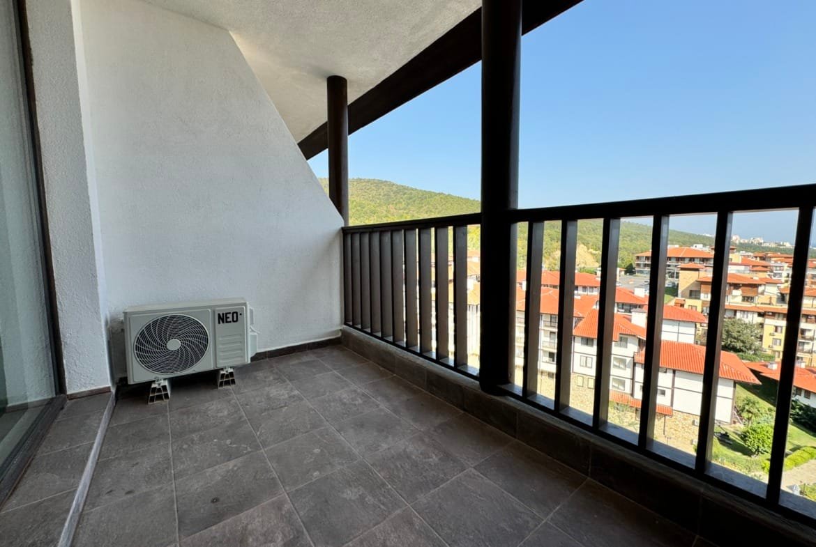 Балкон с современным дизайном, кондиционером и видом на город в Болгарии, идеальное место для отдыха и продажи недвижимости.