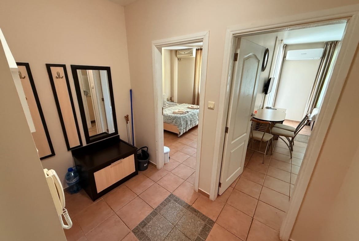 Светлый холл с зеркалами, вход в спальню и столовую, уютные комнаты, характерные для недвижимости в Болгарии.