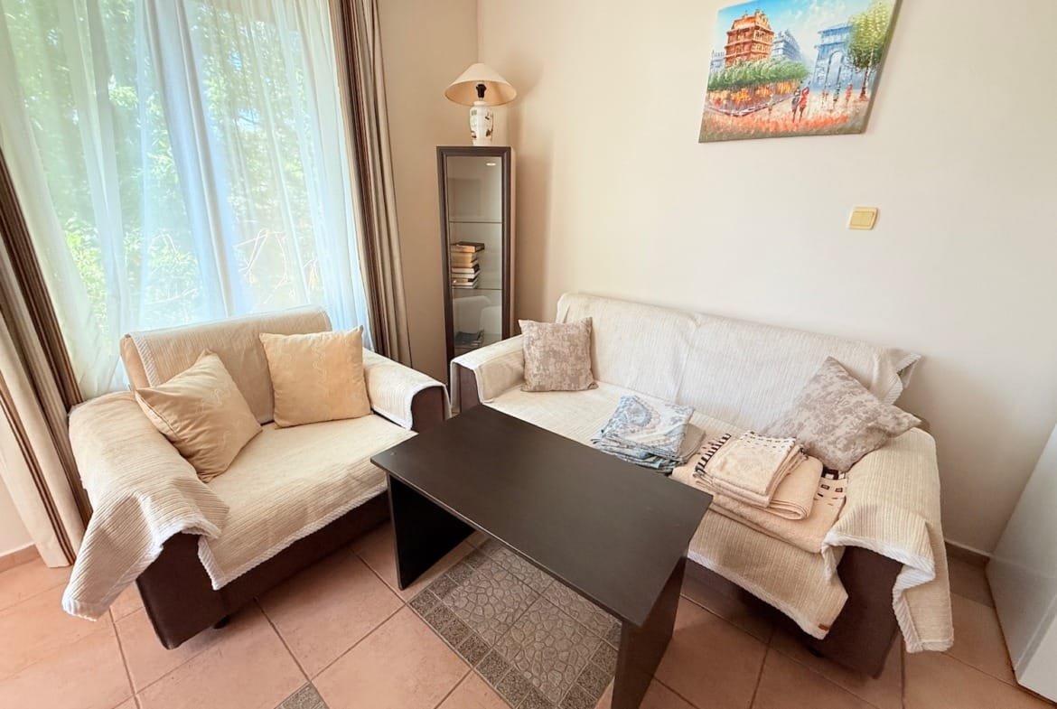 Уютная гостиная с двумя диванами, журнальным столиком и светлыми шторами, идеально подходит для жизни в Болгарии.