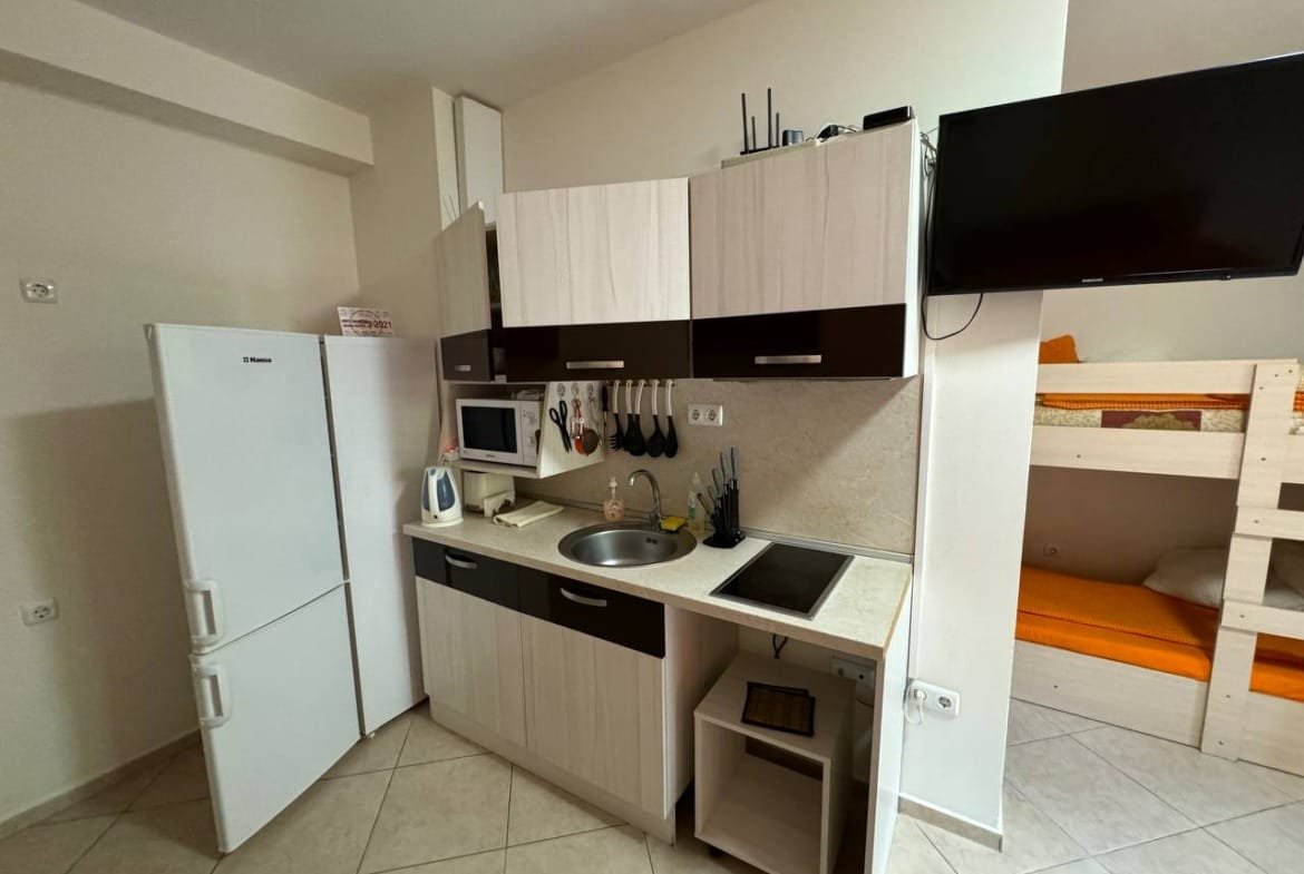 Современная кухня с бытовой техникой, чистыми линиями и светлыми тонами, подходит для аренды недвижимости в Болгарии.