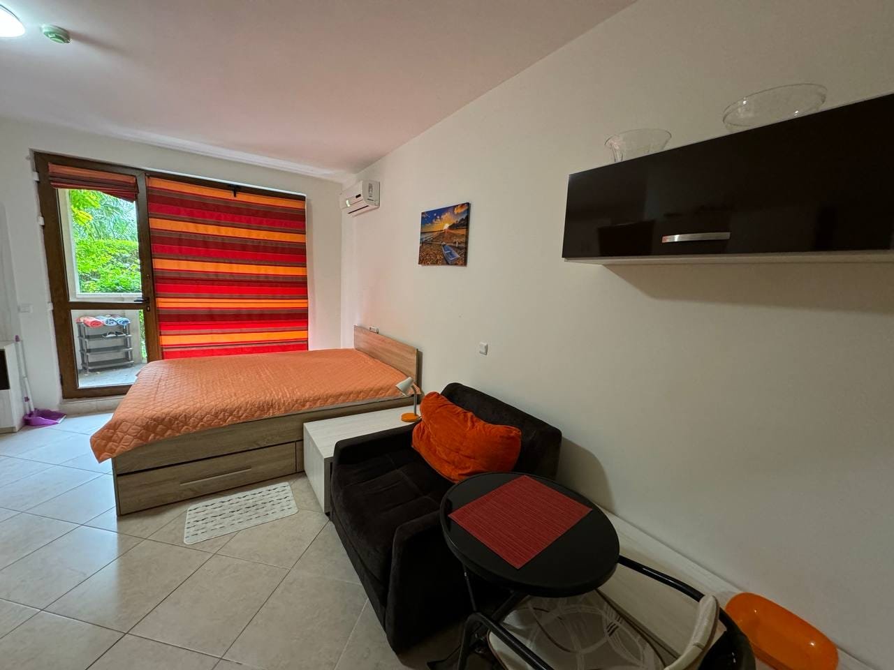 Уютная квартира с современной мебелью, двуспальной кроватью и балконом, идеальная для покупки или аренды в Болгарии.