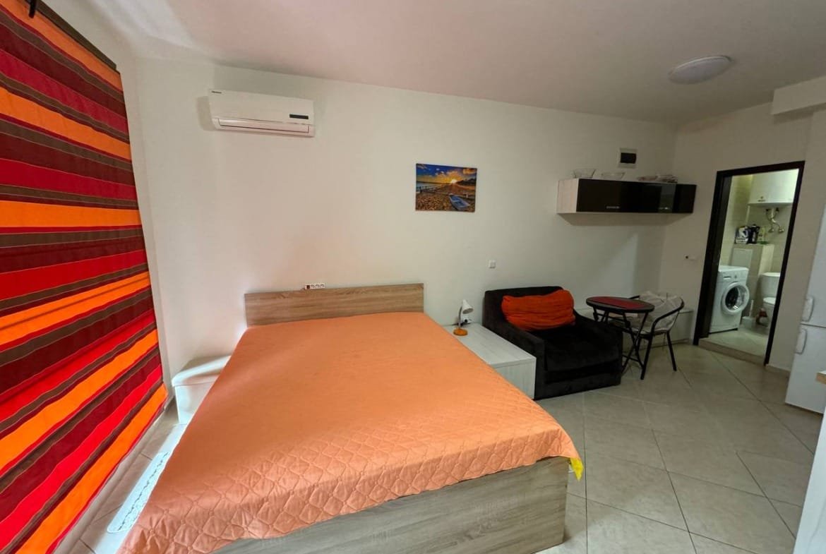 Удобная квартира в Болгарии с одной спальней, диваном и яркими шторами, идеальна для покупки или аренды.