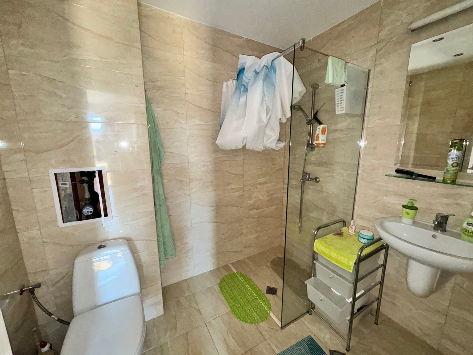 Современный стильный интерьер ванной комнаты с душевой кабиной Современная ванная комната с душевой кабиной, туалетом и раковиной, оформленная в светлых тонах для комфортного проживания в Болгарии.