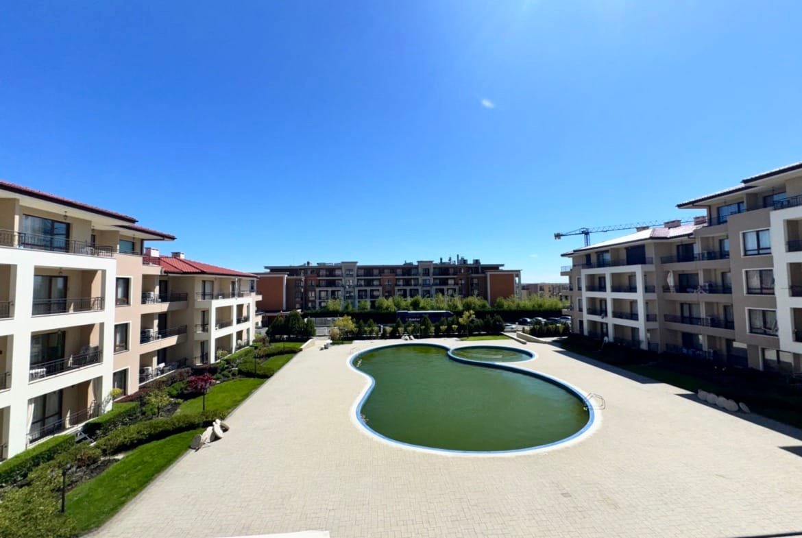 Современный комплекс с бассейном, зелеными насаждениями и светлой архитектурой, предлагающий жилье в Болгарии.