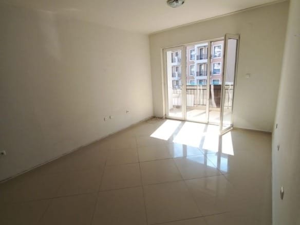 Светлая комната с большими окнами, панорамный вид на улицу, идеальное предложение для покупки недвижимости в Болгарии.