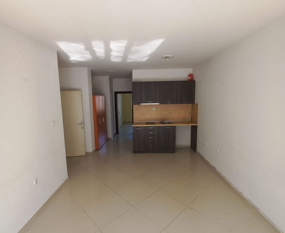 Светлая квартира в Болгарии с открытой планировкой, плиточным полом и кухонным уголком, готовая для продажи или аренды.