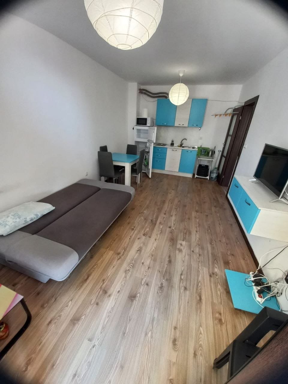 Современная квартира-студия с удобной меблировкой и кухней Современная квартира в Болгарии с открытой планировкой, кухней в голубых тонах и уютной зоной для отдыха.