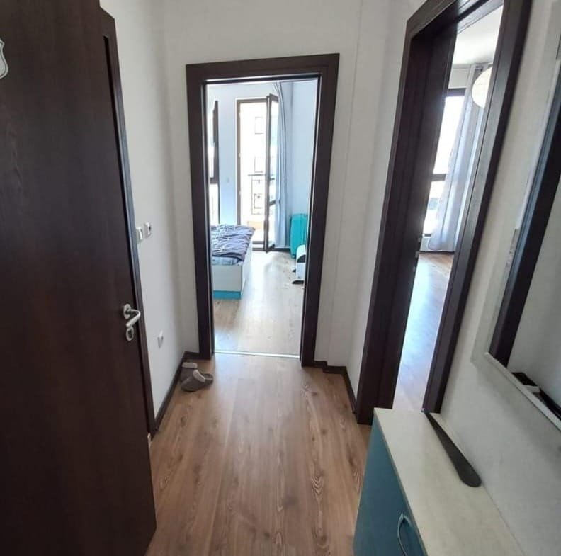 Светлый коридор с дверями ведущими в комнаты, современный интерьер, акцент на продаже недвижимости в Болгарии.