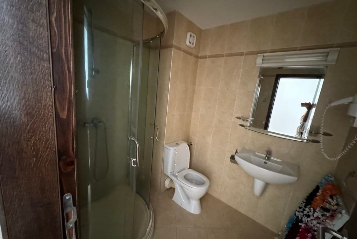 Современная ванная комната с душевой кабиной, унитазом и умывальником, оформленная в светлых тонах.