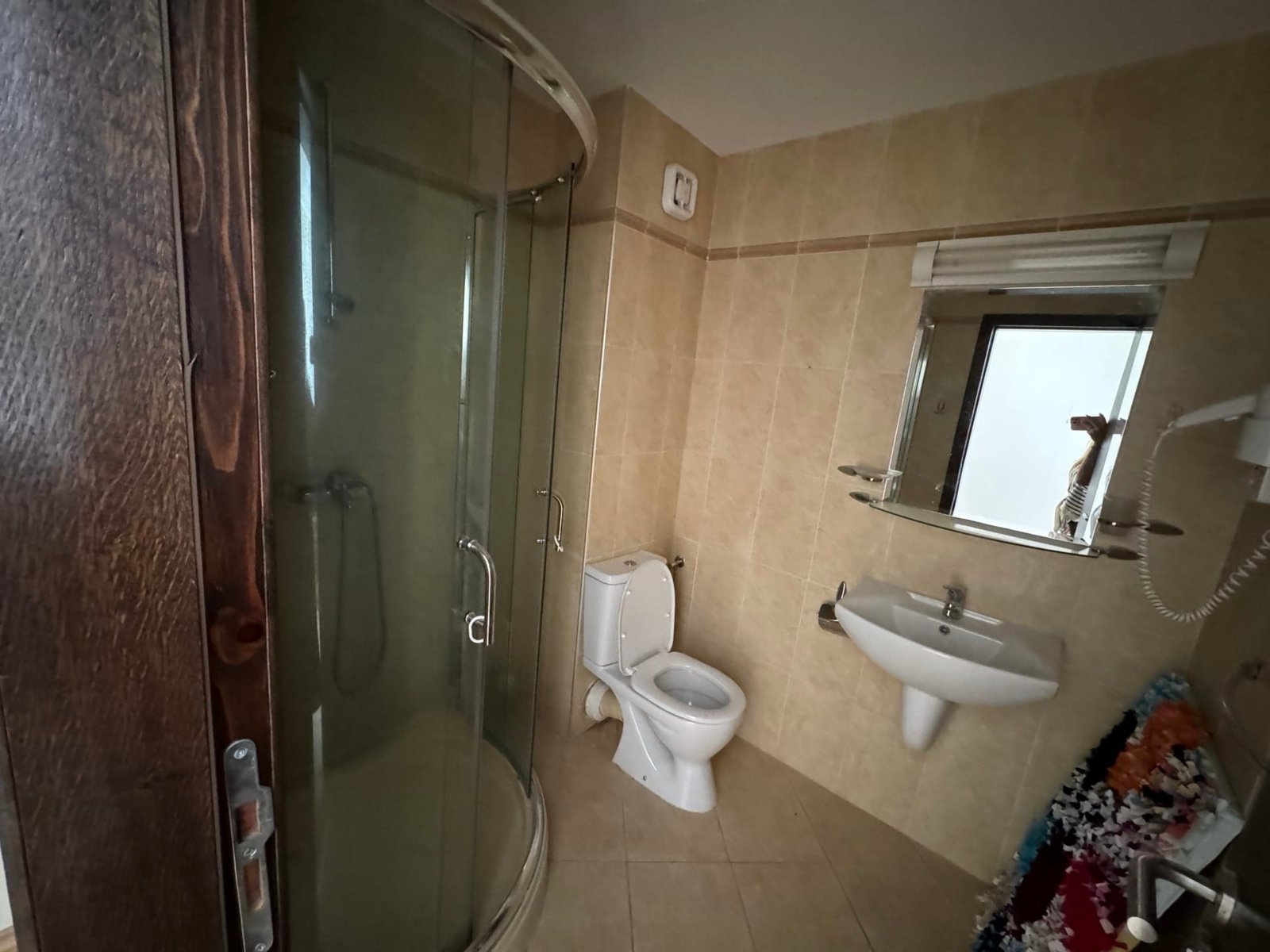 Современный санузел с душевой кабиной и стандартной сантехникой Современная ванная комната с душевой кабиной, унитазом и умывальником, оформленная в светлых тонах.