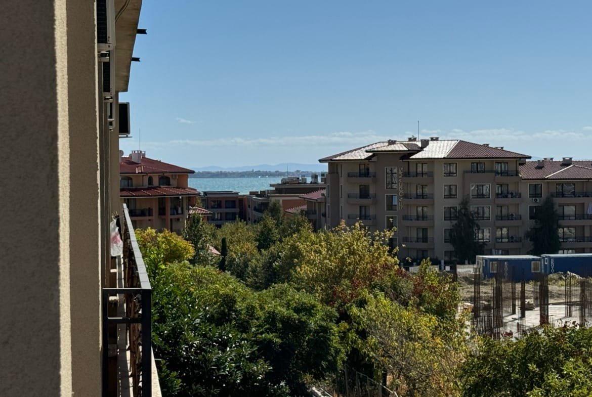 Вид на побережье Болгарии с жилыми домами на фоне зелени и ясного неба. Идеальное место для покупки недвижимости у моря.