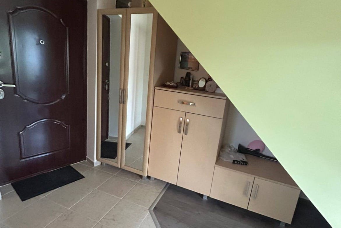 Входное пространство с угловым шкафом и зеркалом, светлые тона, подходит для покупки недвижимости в Болгарии.