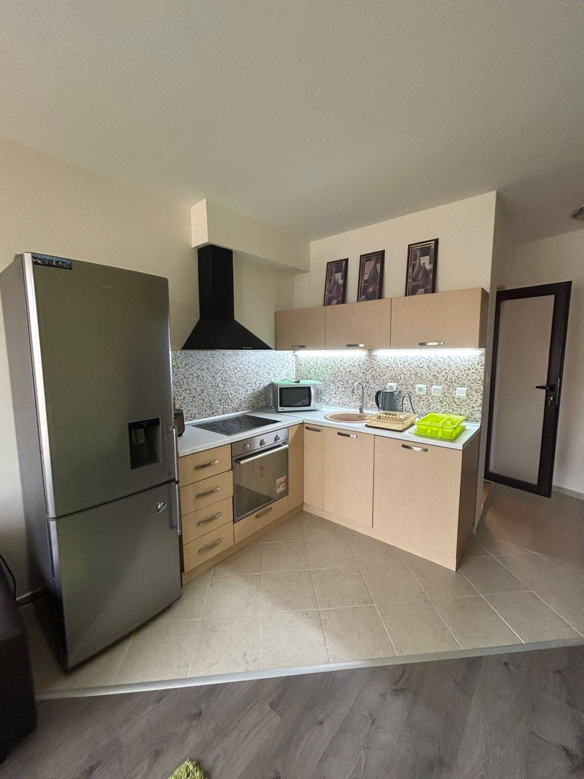 Современная кухня с бытовой техникой и стильным дизайном Современная кухня в квартире в Болгарии, со встроенной техникой и светлыми шкафами, идеально подходит для жизни и отдыха.