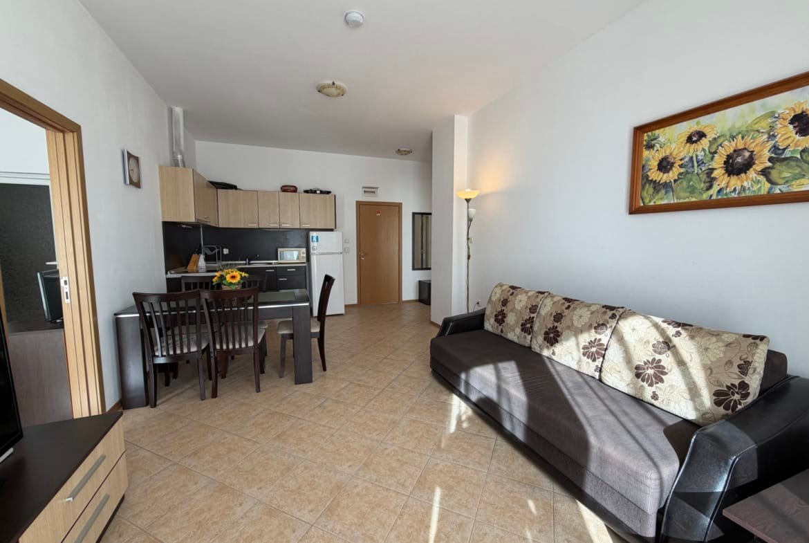 Современная гостиная с кухней в квартире для продажи в Болгарии, светлые тона, комфортная мебель и уютная атмосфера.