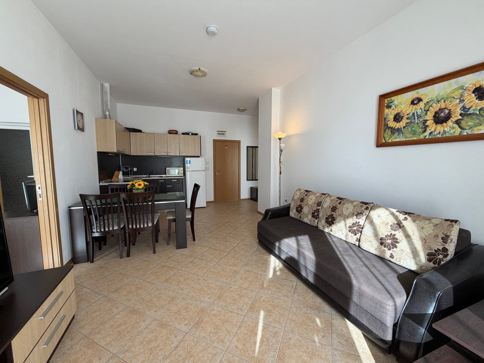 Современная гостиная с кухней в квартире для продажи в Болгарии, светлые тона, комфортная мебель и уютная атмосфера.