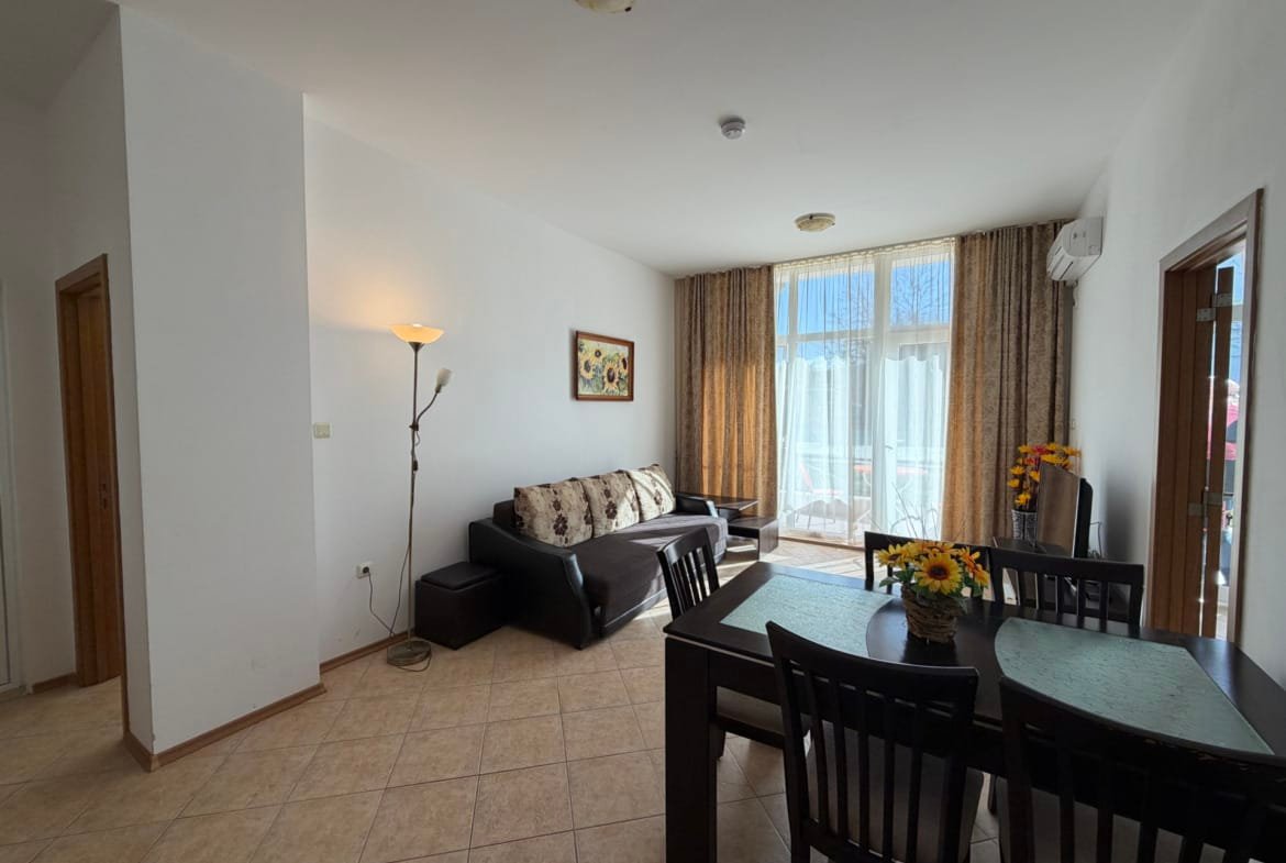 Светлая квартира с современным мебельным ансамблем, кухонным столом и уютной гостиной в Болгарии, идеальна для комфортного отдыха.