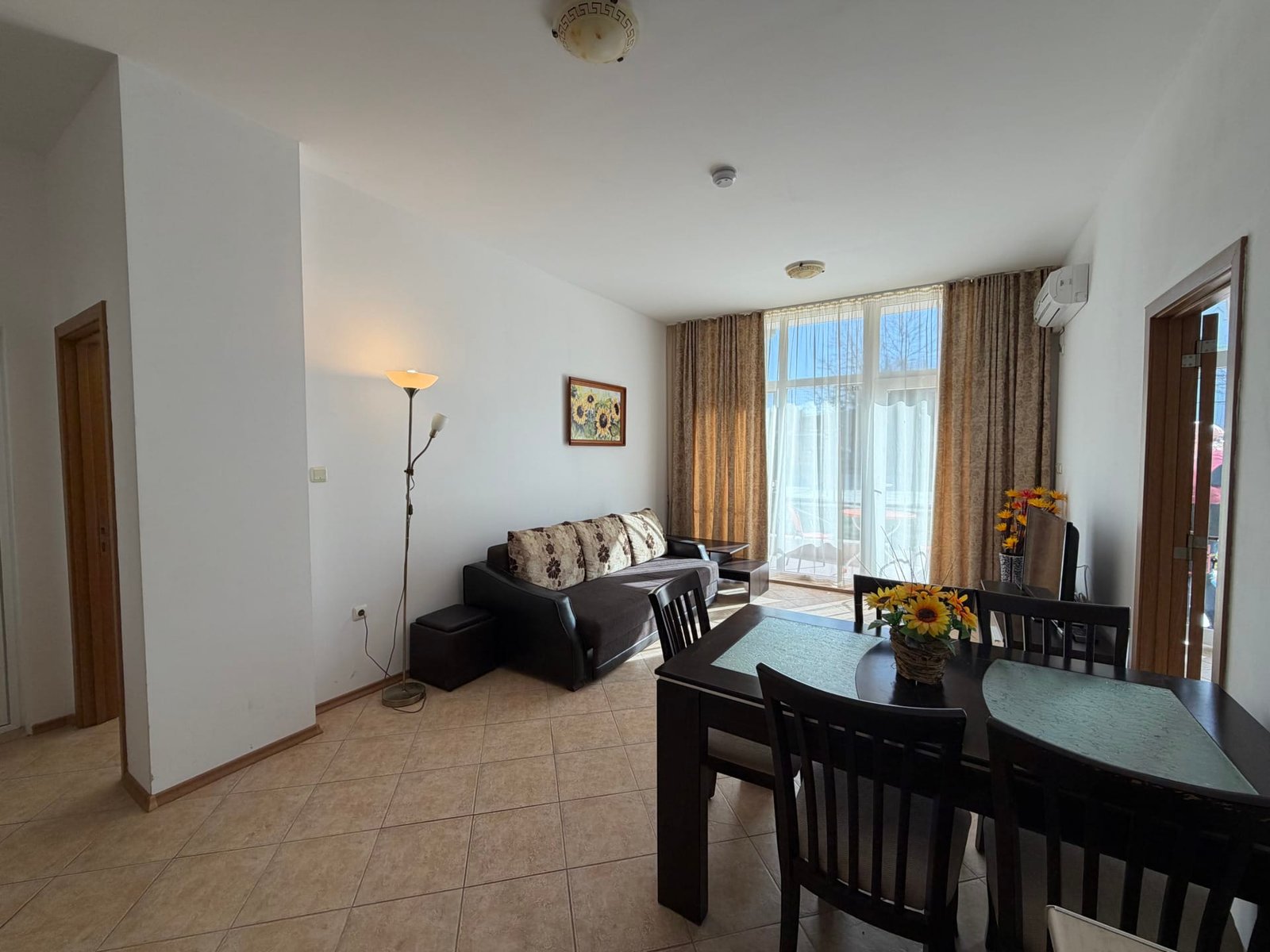 Светлая квартира с современным мебельным ансамблем, кухонным столом и уютной гостиной в Болгарии, идеальна для комфортного отдыха.