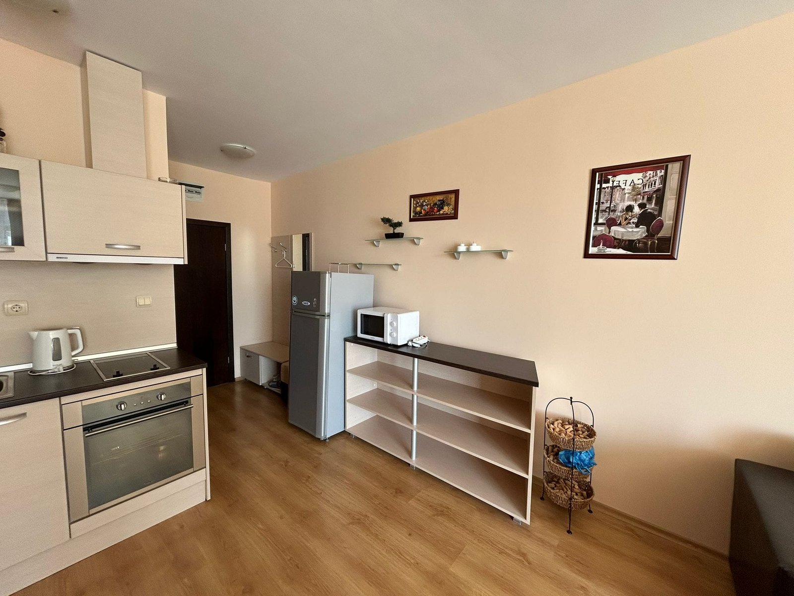 Современная кухня с холодильником и уютной атмосферой Современная кухня с техникой, светлыми стенами и функциональной мебелью, идеальная для жизни в Болгарии.