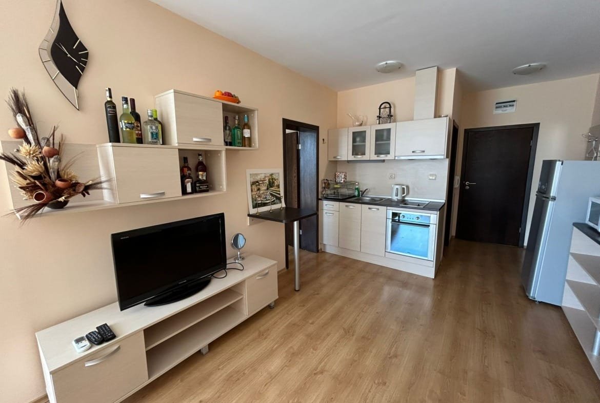 Современная кухня с минималистичной мебелью, телевизором, магазином и техникой для комфортного проживания в Болгарии.