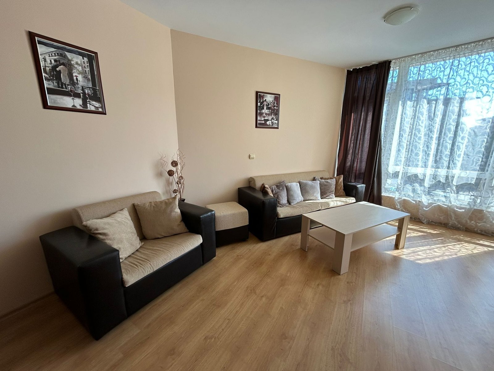 Современная гостиная с диванами и светлым интерьером Светлая гостиная с мягкой мебелью, столом и занавесками, подходит для продажи или аренды недвижимости в Болгарии.