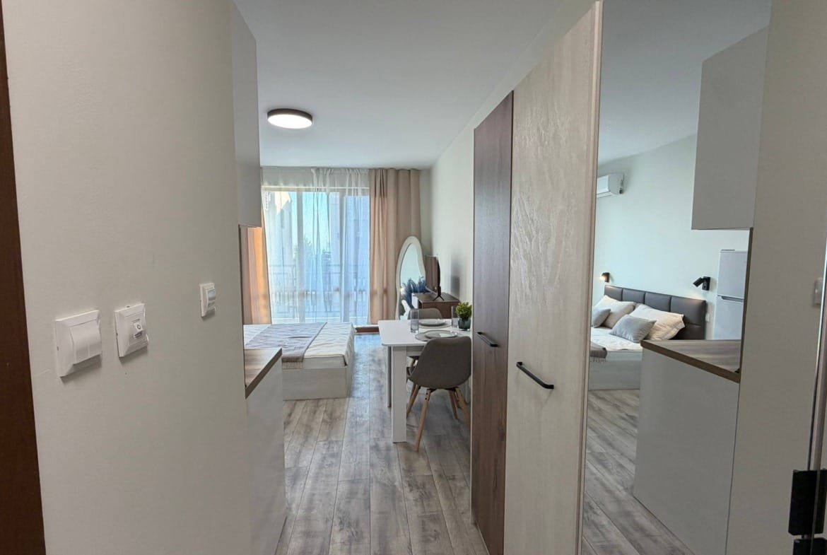 Современная квартира в Болгарии с открытой планировкой, стильной мебелью и большими окнами, обеспечивающими естественное освещение.