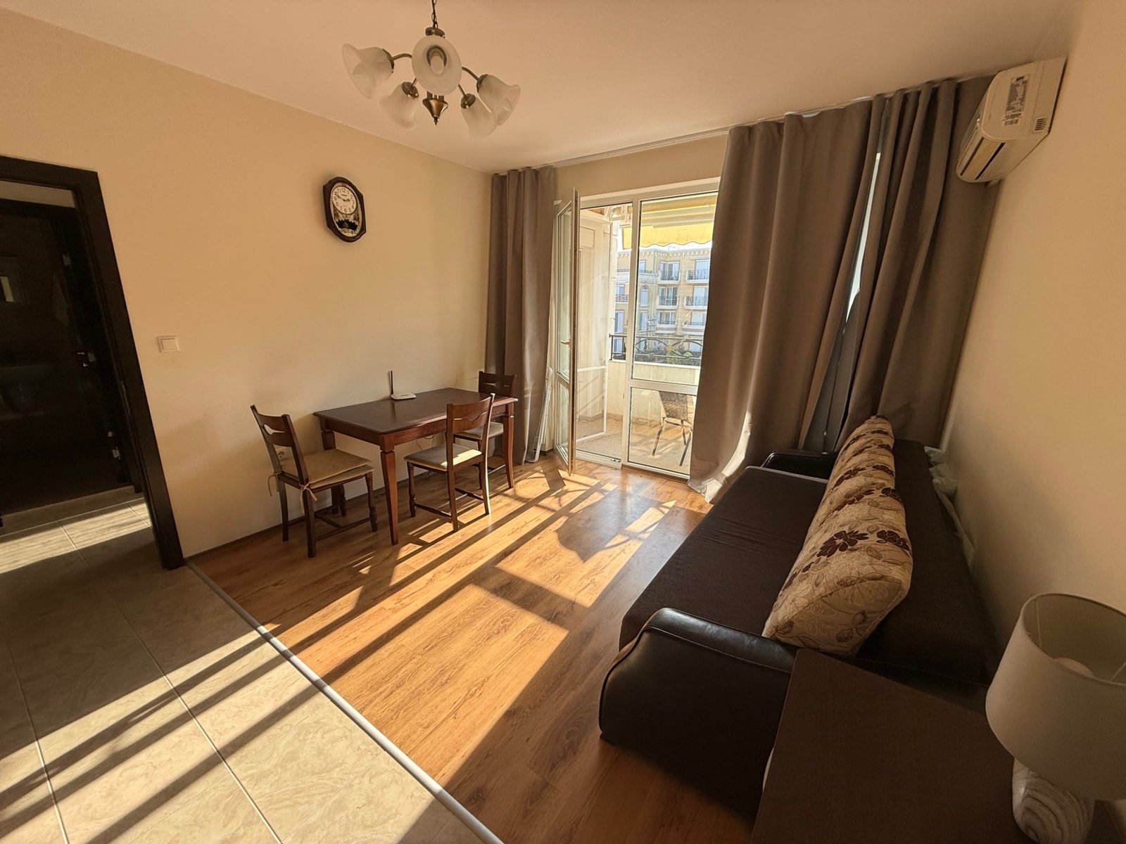 Современный интерьер квартиры в Болгарии с мебелью, балконом и ярким освещением, подходящий для продажи или аренды.