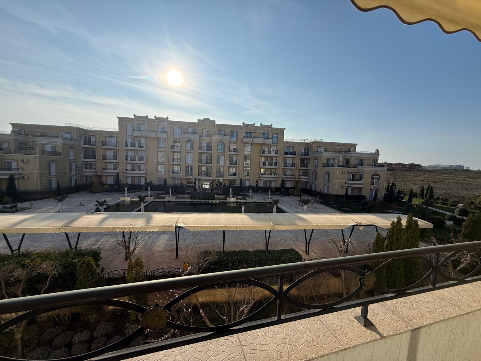 Современный жилой комплекс в Болгарии с солнечной террасой, ухоженной территорией и зелеными насаждениями для жизни и отдыха.