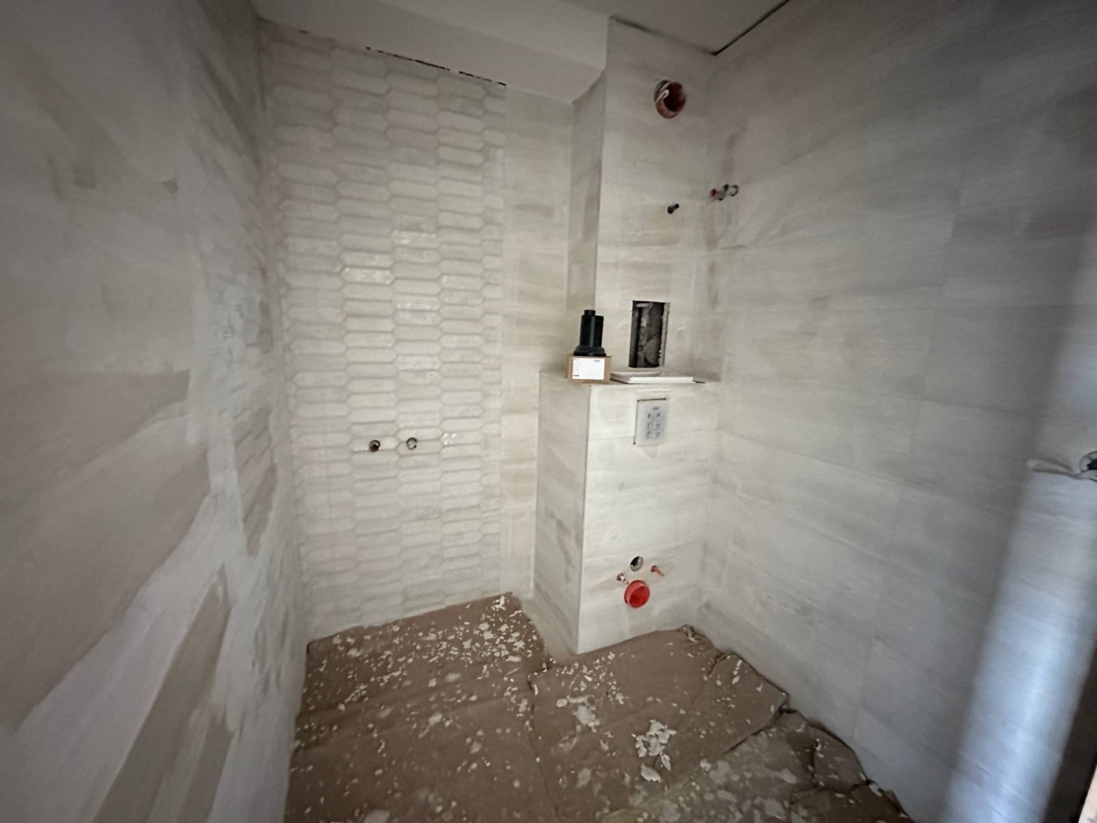 Современная ванная комната в стадии ремонта с белыми стенами и плиткой, расположенная в комплексе “La Mer Gold”.